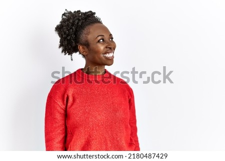 Young african american woman wearing casual clothes over isolated background looking away to side with smile on face, natural expression. laughing confident. 