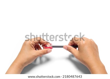 Women's hands  sharpening pencils isolated on white background Royalty-Free Stock Photo #2180487643