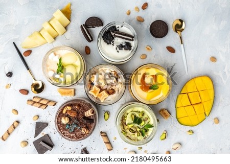 Large collection of Ice cream, delicious gelati with fresh pistachio, chocolate, caramel, melon, mango, chocolate chip sandwich cookies with aromatic vanilla pod on white.