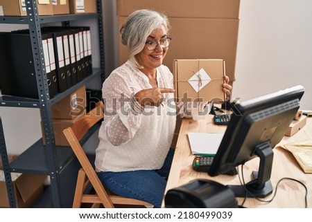Middle age woman ecommerce business worker having video call at office