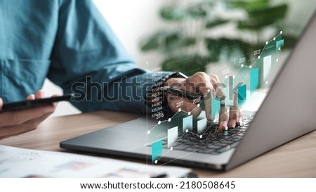 Businessman analyzing digital financial balance sheet of company working with digital virtual graphic design. Calculating long-term investment financial data icon on touch screen