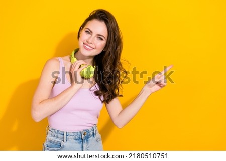 Portrait of pretty positive lady direct finger empty space offer proposition isolated on yellow color background