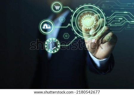Businessman uses a pen to write in the technology circle and has connections to digital markets such as shopping, cloud icons, and smartphone technology.