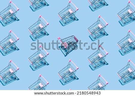Pattern of supermarket shopping cart on pastel blue background. Creative design for packaging. Online shopping. Black friday sale concept. Break the pattern. Sustainable, minimalist lifestyle. Royalty-Free Stock Photo #2180548943