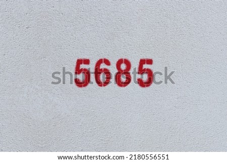 Red Number 5685 on the white wall. Spray paint.
