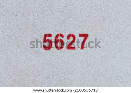 Red Number 5627 on the white wall. Spray paint.
