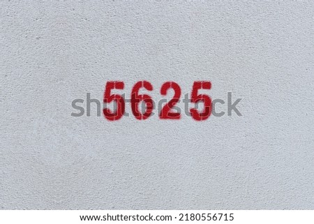 Red Number 5625 on the white wall. Spray paint.
