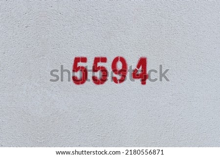 Red Number 5594 on the white wall. Spray paint.
