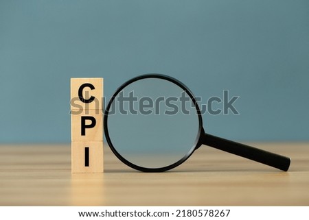 CPI - Consumer Price Index symbol.Letter block in word CPI abbreviation of consumer price index with a magnifying glass on blue background.copy space. Business and CPI, consumer price index concept. Royalty-Free Stock Photo #2180578267
