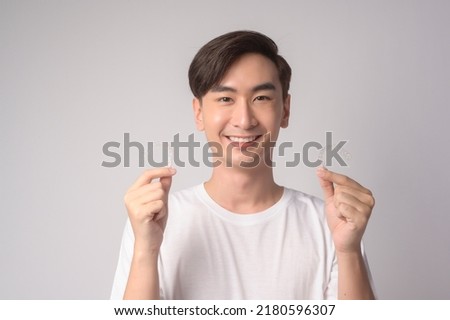 A Young smiling man holding invisalign braces over white background studio, dental healthcare and Orthodontic concept.	
