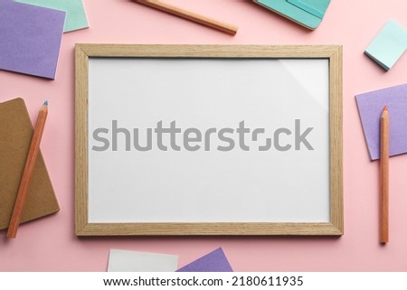 Blank white board with stationery on light pink background, flat lay. Space for text