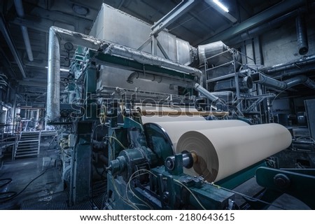 Paper production machine in wastepaper recycling factory. Paper and pulp mill. Royalty-Free Stock Photo #2180643615