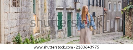 BANNER, LONG FORMAT Woman tourist on background of Scenic panorama view of the historic town of Risan at famous Bay of Kotor on a beautiful sunny day with blue sky and clouds in summer, Montenegro