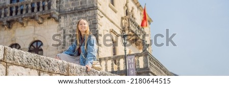 BANNER, LONG FORMAT Woman tourist enjoying Colorful street in Old town of Perast on a sunny day, Montenegro. Travel to Montenegro concept. Scenic panorama view of the historic town of Perast at famous