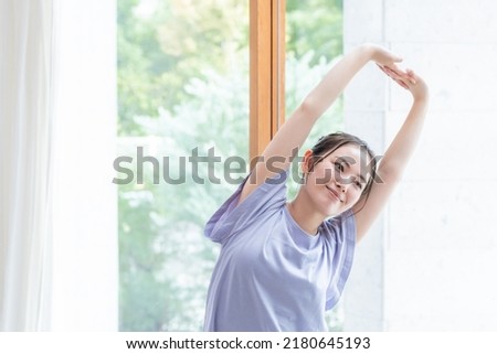 Young Asian woman exercising indoors Royalty-Free Stock Photo #2180645193