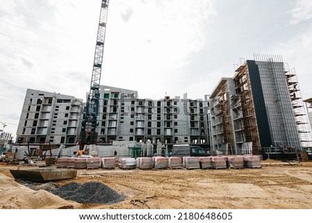 cranes at the construction site of stylish houses with against the blue sky. High quality photo