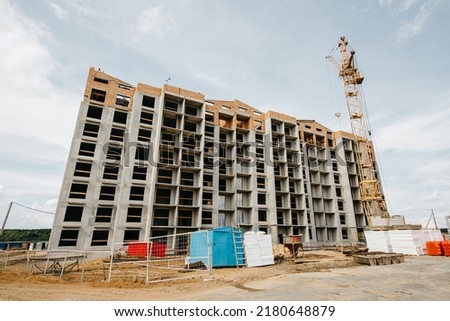 cranes at the construction site of European-style houses with multiple entrances. High quality photo