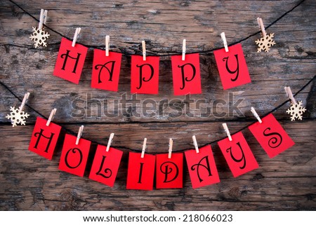 Happy Holidays Greetings on red Tags Hanging on a Line with Snowflakes, Christmas or Winter Background Royalty-Free Stock Photo #218066023