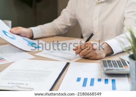 Close up hand of stress asian young employee business man, male calculate tax income and expenses, bills, credit card for payment or payday on table at home office. Financial, finance people concept.