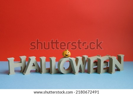 Halloween letters and pumpkin and red-blue background underside photo