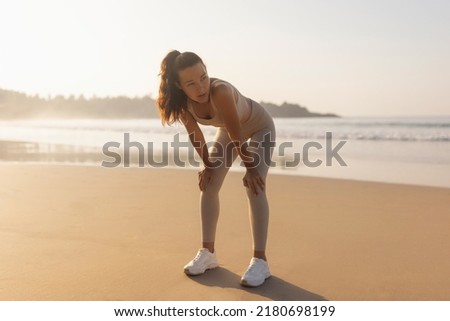 Tired Sporty Woman After Running Hard Outdoors on the Beach in the Morning Royalty-Free Stock Photo #2180698199