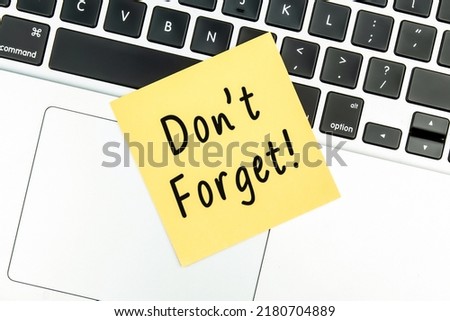 “Don’t forget”  text on yellow sticky notes located on the laptop.
