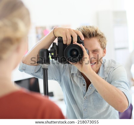 Fashion photographer shooting model in studio