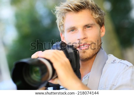 Young photographer shooting with digital camera