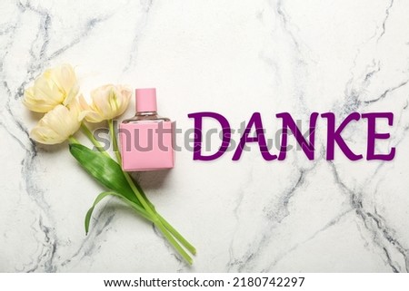 Perfume, flowers and word DANKE (German for Thanks) on light background