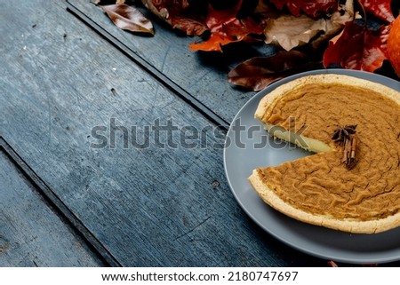 Composition of autumn leaves, spices and pie on wooden background. Halloween, autumn, tradition and celebration concept.