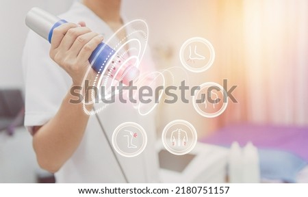 Physiotherapist using shockwave with virtual health care symbol and pain icons medical on interface. modern virtual screen interface, health problem and medical technology concept.