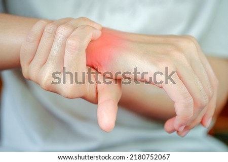 Woman has wrist pain due to heavy use. Health care concept. Royalty-Free Stock Photo #2180752067