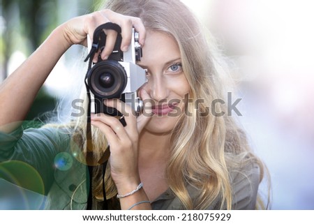 Beautiful cheerful girl using vintage photo camera