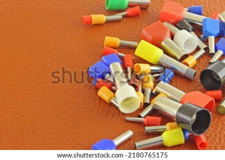 Coloured crimp terminals for different wire sizes. Copper sleeves for crimping electrical cables. Ferrules. Selective focus, copy space Royalty-Free Stock Photo #2180765175