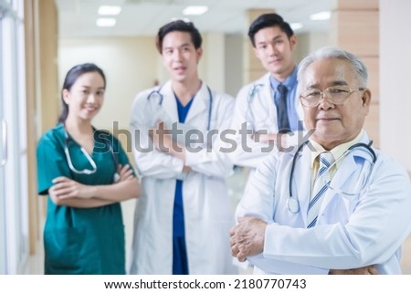 Portrait Group of Asian doctor and nurse crossing arm with smiling. Professional medical team standing in hospital office ward and giving encouragement to patient people after work in recovery room. Royalty-Free Stock Photo #2180770743