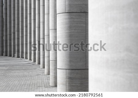 Abstract architectural picture of series of partially illuminated columns made of modern materials standing in a semicircle