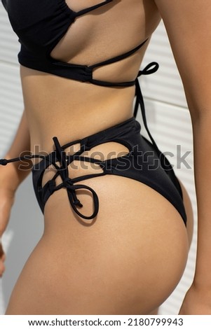 Woman wearing black bikini, detail, no face