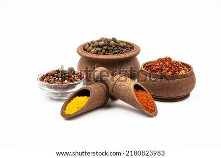Spices in wooden bowls and spoons, pepper mixture in glass bowl isolated on white background. Royalty-Free Stock Photo #2180823983