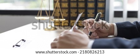 Lawyers or judges sign documents in accordance with legal and fair terms of agreement, Legal Ethics and Integrity, scales of justice, law hammer, Litigation and legal services. Royalty-Free Stock Photo #2180826213