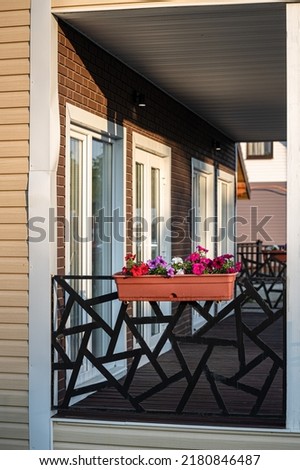 a tray with natural flowers hanging on the veranda of the house. High quality photo
