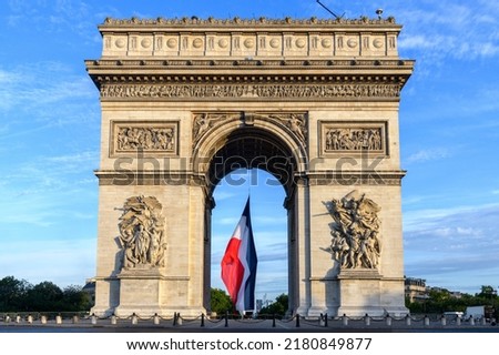 Early in the morning, the French flag is installed on the Arc de Triomphe for the Bastille Day parade. Royalty-Free Stock Photo #2180849877