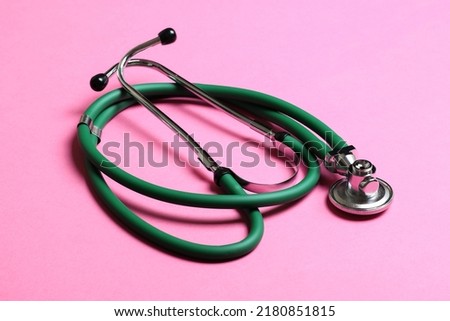 Top view of green stethoscope on colorful background. Medical diagnosis tool concept.