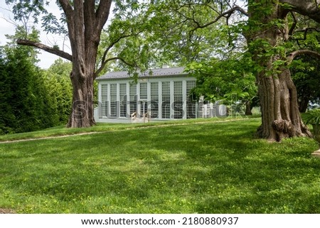 White orangery at Hampton National Historic Site. Greenhouse-like structure with furnace underneath provided citrus fruit in the winter. A sign of wealth for Ridgely family. Old gnarled trees. 