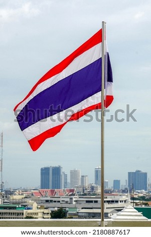 Thailand flag isolated on sky background. Thailand flag wave in the wind with beautiful blue sky and sunlight.								