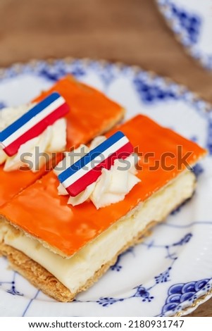 Tompouce pastry cake with Dutch flag for Kings Day   Royalty-Free Stock Photo #2180931747