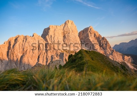 Stunning view of a person enjoying the view of Monte Pelmo from the summit of Col de la Puina. Monte Pelmo was the very first high mountain of the Dolomites that was climbed, Italy. Royalty-Free Stock Photo #2180972883