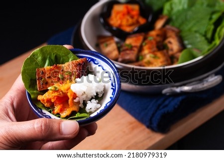 Asian food concept homemade Korean Grilled pork belly BBQ Samgyeopsal-gui with kimchi and shiso and salad on black background with copy space Royalty-Free Stock Photo #2180979319