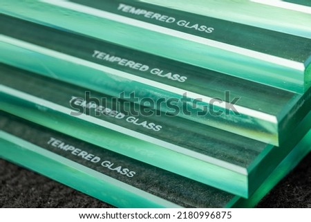Toughened glass, protection of glass panes in a special furnace, Burnt inscription denoting ready and protected material against easy breakage. Glass industry Royalty-Free Stock Photo #2180996875