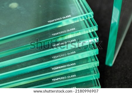Toughened glass, protection of glass panes in a special furnace, Burnt inscription denoting ready and protected material against easy breakage. Glass industry Royalty-Free Stock Photo #2180996907