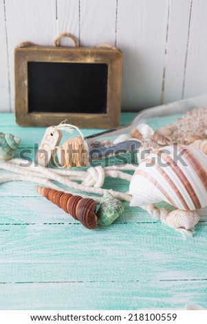 Marine items on wooden background. Empty blackboard for text. Sea objects on wooden planks. Selective focus.